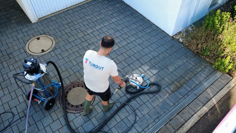Pflasterreinigung einer Einfahrt mit Flächenreiniger und Absaugung