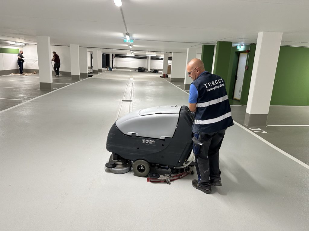 Tiefgaragenreinigung mit Scheuersaugmaschine durch einen Mitarbeiter der Turgut Gebäudereinigung